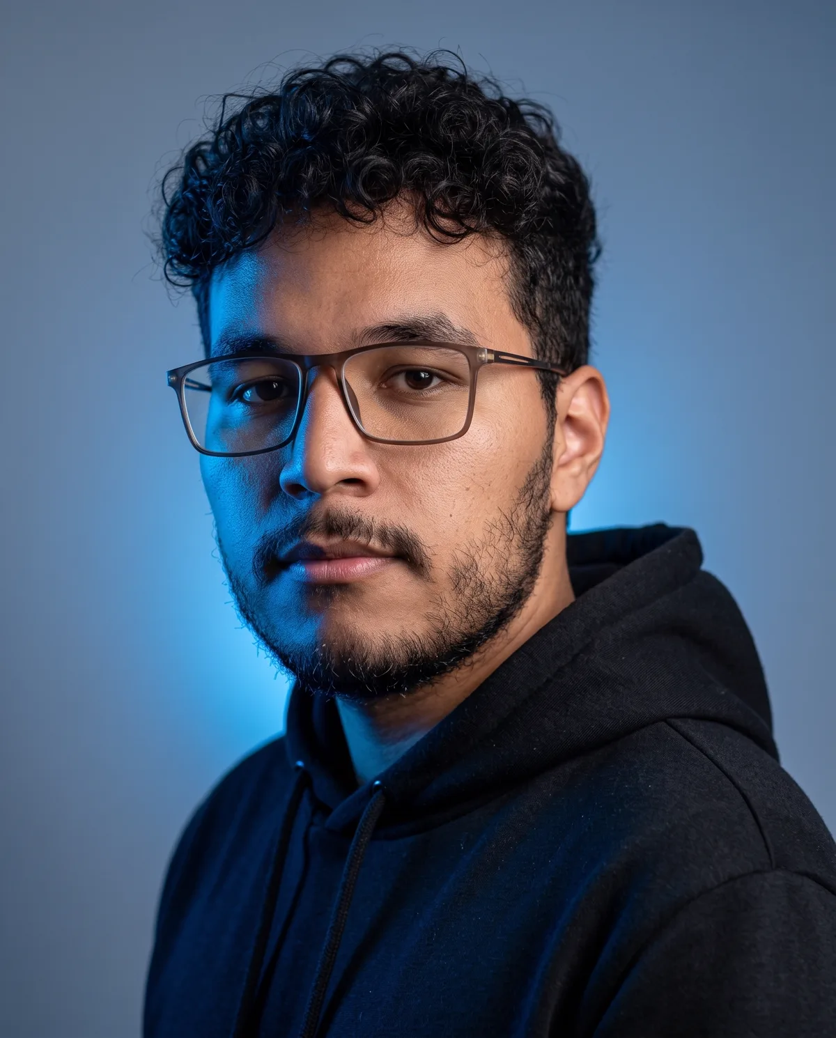 Retrato de Érick Rodrigues, diretor de arte, em estúdio sob luz azul