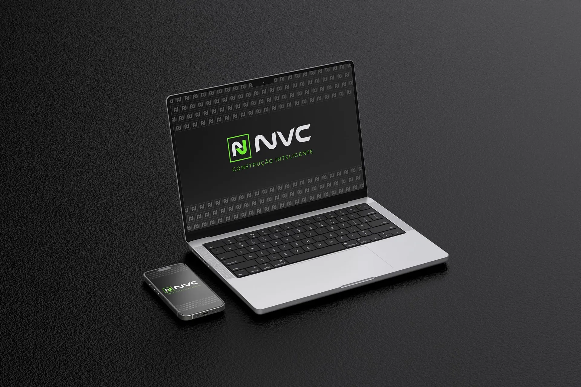 Notebook e celular exibindo a marca NVC Tech sobre padronagem do monograma