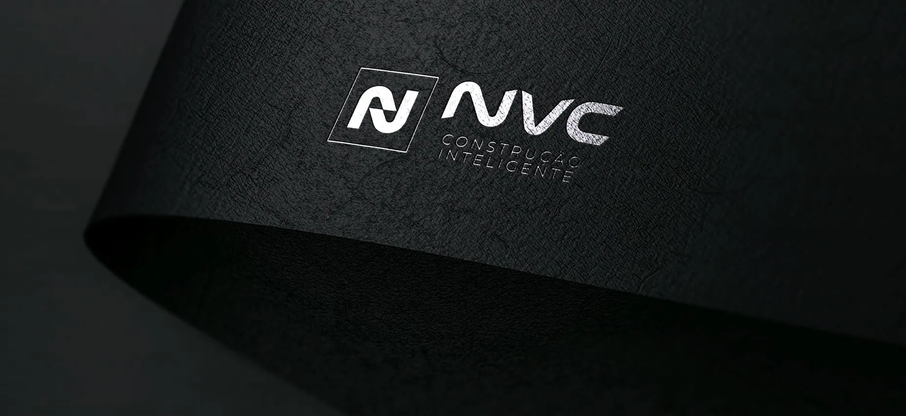 Prancheta 4 NVC logo mockup on dark textured paper